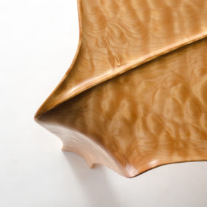 Close-up view of the signature curved leg and raised leaf design on our hand-carved Kvalheim Coffee Table