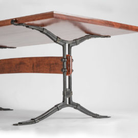 Close-up view of the hand-forged steel base on our hand-carved bubinga Salin Dining Table