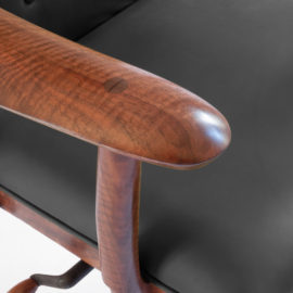 Close-up view of the hand carved armrest on our custom office chair, The McCorkle Chair